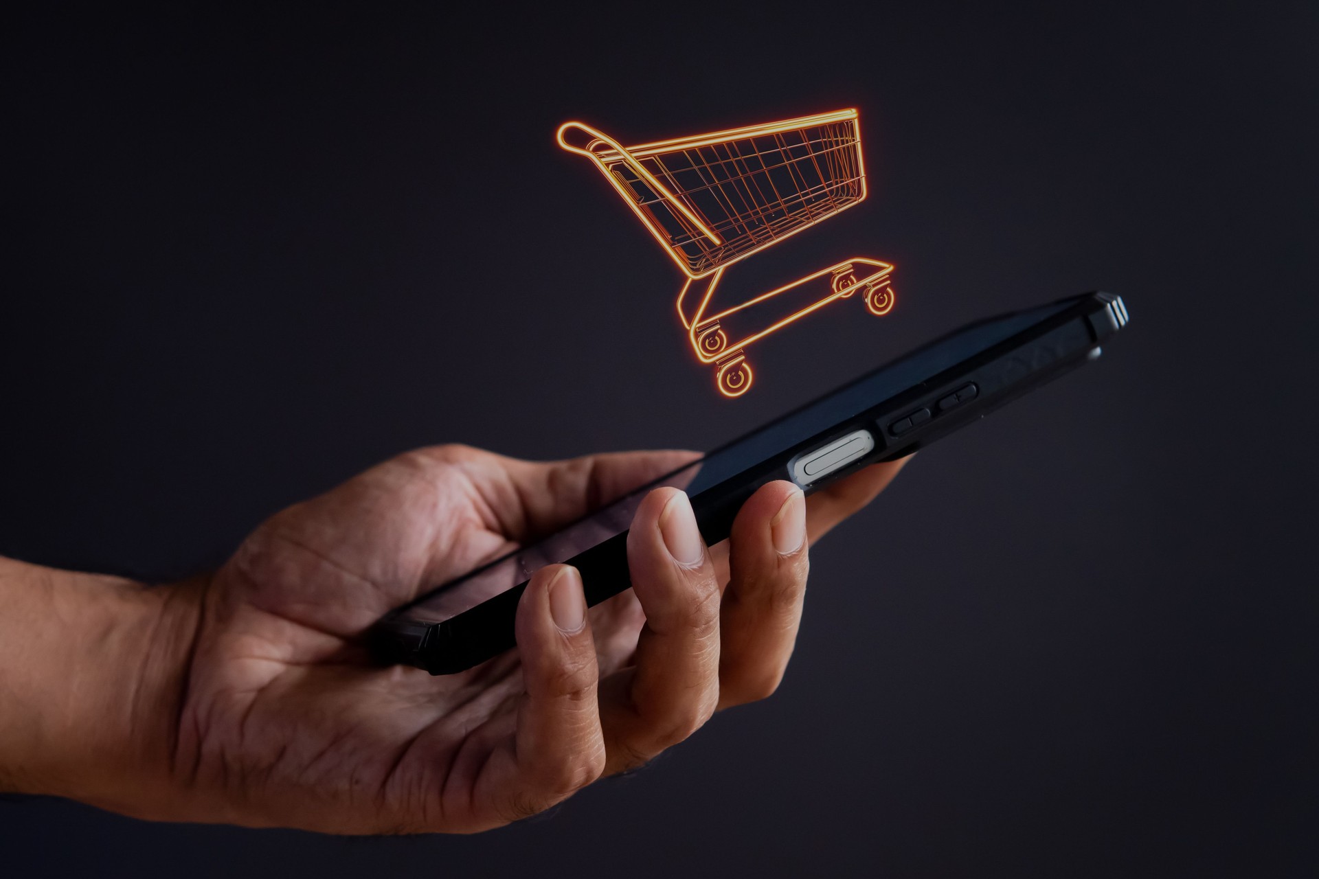 Smartphone segurando a mão com ícone de carrinho de compras.